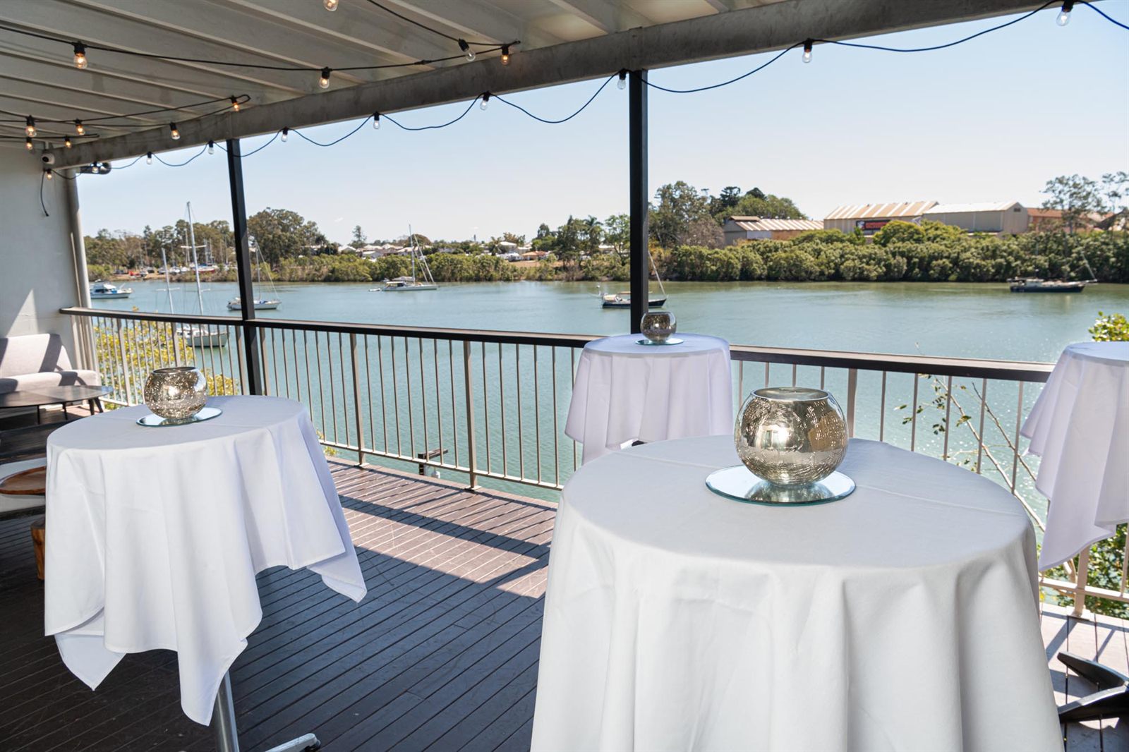Cocktail tables on the Burnett Room balcony overlooking the Burnett River