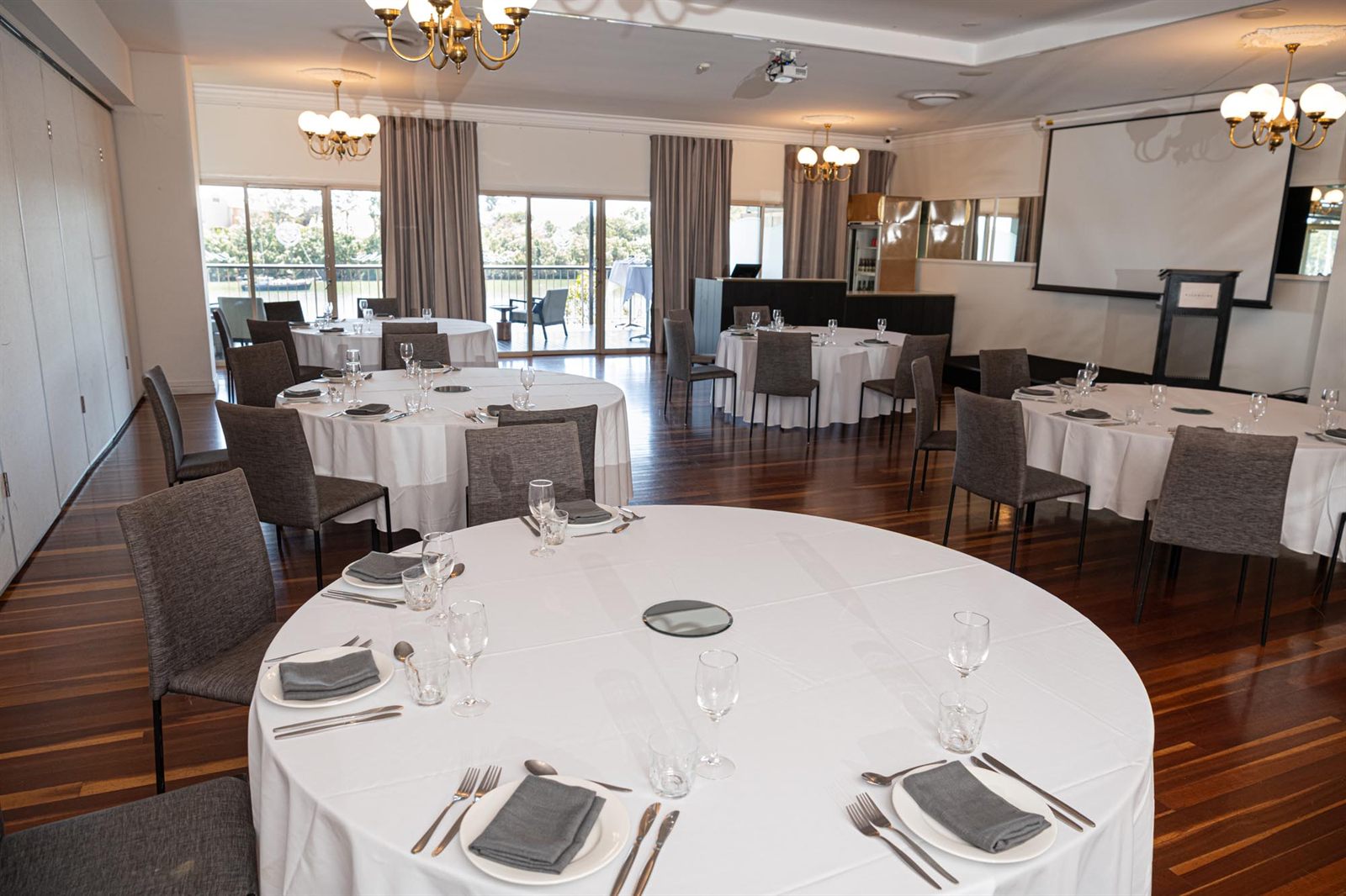 The Burnett Room set with round banquet tables, the river through the windows
