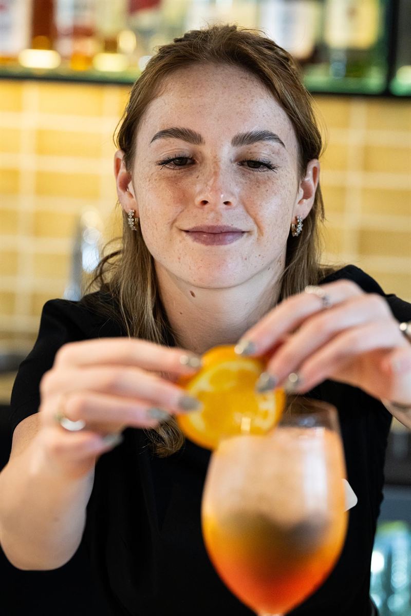 A spritz being garnished with orange at the H2O bar