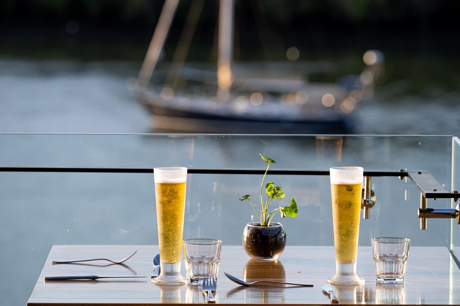 Cold beers on the deck at H2O, with a yacht on the Burnett River behind